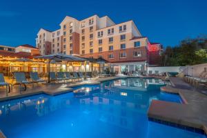a swimming pool with chairs and a hotel at night at Hilton Garden Inn Scottsdale Old Town in Scottsdale