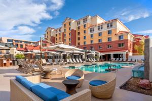 un hôtel avec une piscine, des chaises et un bâtiment dans l'établissement Hilton Garden Inn Scottsdale Old Town, à Scottsdale