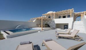 Agia ParaskeviにあるLovely Santorini Villa - 2 Bedroom Villa - Private Jacuzzi and Charismatic Interior - Vothonasのスイミングプールと椅子が備わるヴィラです。