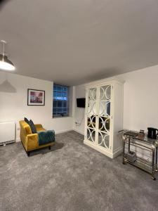 a living room with a yellow couch and a tv at No 8 Plants Yard Modern studio in Worksop in Worksop