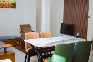 Cette chambre dispose d'une table, de chaises et d'une télévision. dans l'établissement Stay Apartment, à Kigali
