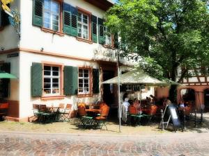 un grupo de mesas y sillas frente a un edificio en Historischer Adelshof am Marktplatz, Atelier 70 m² en Weinheim