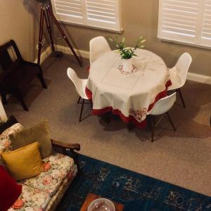 una sala de estar con una mesa con un jarrón de flores. en Bundanoon Bijou Southern Highlands Accommodation, en Bundanoon