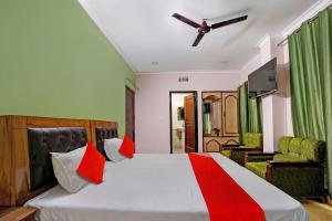 巴雷利的住宿－OYO Hotel Bonzer，一间卧室配有一张带红色枕头的大床