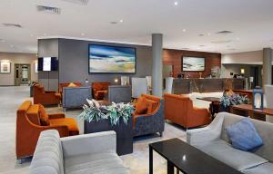 a hotel lobby with couches and tables and chairs at DoubleTree by Hilton Swindon Hotel in Swindon