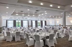 a banquet hall with white tables and white chairs at DoubleTree by Hilton Swindon Hotel in Swindon