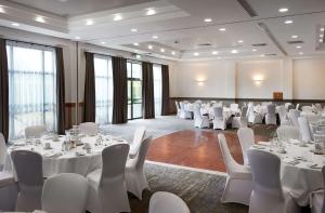 a room with white tables and white chairs in a room at DoubleTree by Hilton Swindon Hotel in Swindon