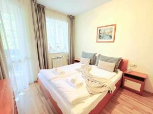 a bedroom with a large white bed in front of a window at Arboro Royal Plaza in Borovets