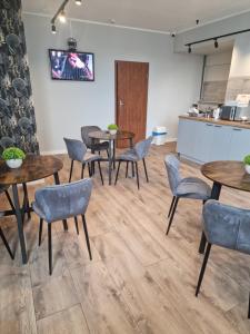 a room with tables and chairs and a kitchen at CZARNA PERŁA in Wrocław