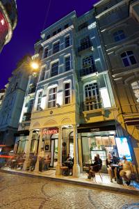 ein großes Gebäude, vor dem Menschen sitzen. in der Unterkunft Anemon Koleksiyon Galata Otel in Istanbul
