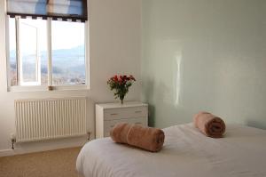 a bedroom with a bed with a vase of flowers on it at Tawel Fryn Bungalow near Dolgellau in Dolgellau