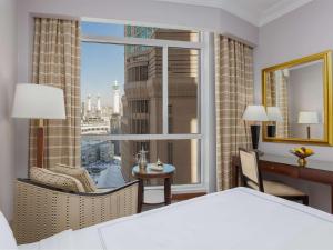 a bedroom with a bed and a window with a view at Swissotel Al Maqam Makkah in Mecca
