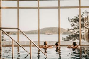 drei Frauen in einem Pool mit Blick auf das Wasser in der Unterkunft Destination Bokenäset in Uddevalla