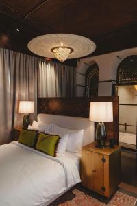 a bedroom with a bed with two lamps and a chandelier at Al Balad Hospitality in Jeddah