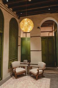 a room with two chairs and a table and a chandelier at Al Balad Hospitality in Jeddah