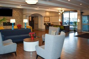 a lobby with a couch and chairs and a table at MainStay Suites MSP Airport - Mall of America in Bloomington