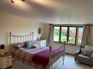 1 dormitorio con 1 cama, 1 silla y 1 ventana en Meadow Barn, en Hereford