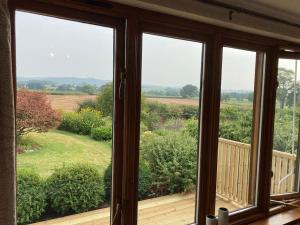a view from a window of a wooden deck at Meadow Barn in Hereford