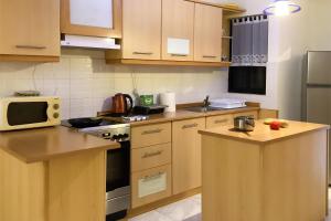 a kitchen with wooden cabinets and a microwave at Well located Apt Buġibba St Paul's Bay - Happy Rentals in St. Paul's Bay