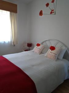 a white bed with red roses on top of it at Sea & You Algarve Apartment in Lagos