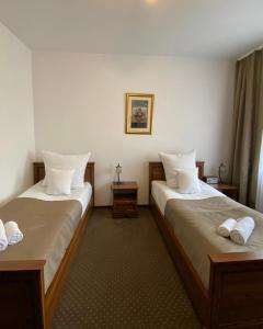 a hotel room with two beds with white pillows at Hotel Constancja in Częstochowa