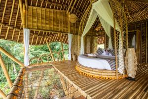a bedroom with a bed on a wooden deck at Magic Hills Bali - Magical Eco-Luxury Lodge in Selat
