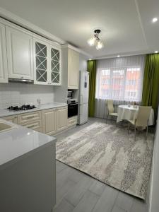 una cucina con un tavolo e un frigorifero bianco di Думан-2 a Almaty