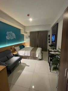 a bedroom with a bed and a table and a couch at MG’s PLACE at Horizons 101 in Cebu City