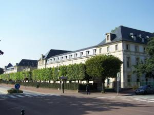 a large white building with a black roof at La Douce Évasion à 13 minutes du château de Versailles in Saint-Cyr-lʼÉcole