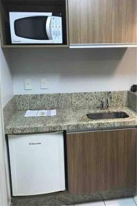 a kitchen with a sink and a microwave at Sun Square Marista Vista Pça do Sol! Hospitais,mercados e cartórios, tudo perto! 301 in Goiânia