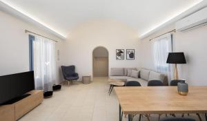 sala de estar con sofá y mesa en Beautiful Santorini Villa - 3 Bedroom Villa - Private Jacuzzi and Charismatic Interior - Vothonas, en Agia Paraskevi