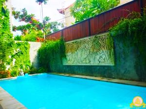 einen Pool in einem Garten mit einem Zaun in der Unterkunft 3Bedroom Villa Kepiting Sanur in Sanur