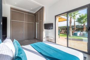 a bedroom with a large bed and a sliding glass door at Villa Dalia, Personnels et option piscine in Marrakesh