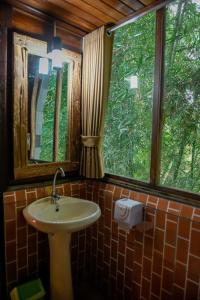 a bathroom with a sink and a window at Abing Dalem - Villa Durian in Tabanan