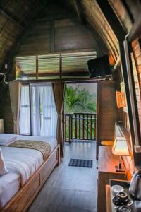 タバナンにあるAbing Dalem - Villa Durianのベッドルーム(ベッド1台付)、バルコニーが備わります。
