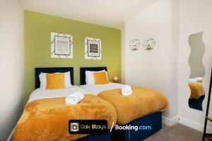 1 dormitorio con 1 cama con almohadas de color naranja y blanco en Fosse Road North By Oak Stays Short Lets & Serviced Accommodation Leicester With Free WiFi en Leicester