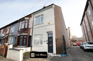 a white house with a black door on a street at Fosse Road North By Oak Stays Short Lets & Serviced Accommodation Leicester With Free WiFi in Leicester