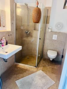 een badkamer met een douche, een wastafel en een toilet bij Golden Loft Berlin in Berlijn
