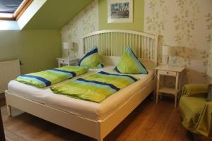 Schlafzimmer mit einem Bett mit gelben und blauen Kissen in der Unterkunft Haus Märtens in Cochem