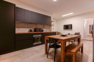 una cucina con tavolo in legno e una sala da pranzo di Sette Chiese Apartments a Bologna