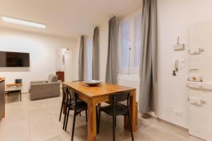 Sette Chiese Apartments في بولونيا: غرفة طعام مع طاولة وكراسي خشبية