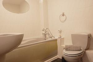 a bathroom with a tub and a toilet and a sink at Sunny Side Up Beach House in Tywyn in Tywyn