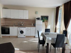 a kitchen and dining room with a table and a washing machine at Apartament Ivanovi A119 in Burgas