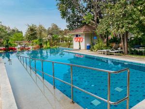 a swimming pool with blue water at Baan Pingkan Wellness Resort in San Kamphaeng