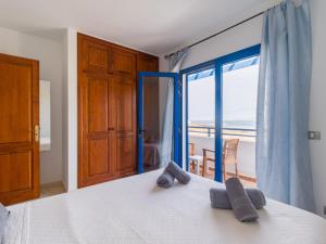 a bedroom with a bed with a view of the ocean at Casa Joral, para surfear en Famara in Famara