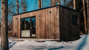 una pequeña cabaña de madera en el bosque en la nieve en Juusa cabin en Otepää