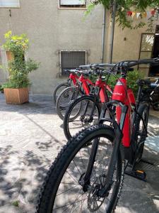 una fila de bicicletas rojas estacionadas en una acera en Albergo La Pietra, en Roccalbegna