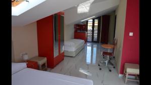 a bedroom with two beds and a desk and a table at KYPRIOTIS LEONIDAS APARTMENTS in Sarti