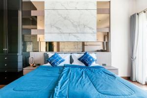 a blue bed in a bedroom with a marble wall at Luxury 31st Top Floor Condo with Swimming Pool in Chiang Mai