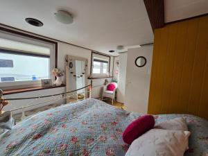 ベンブリッジにあるDUTCH BARGE MALRYNのベッドルーム1室(ピンクの枕が付くベッド1台、窓付)